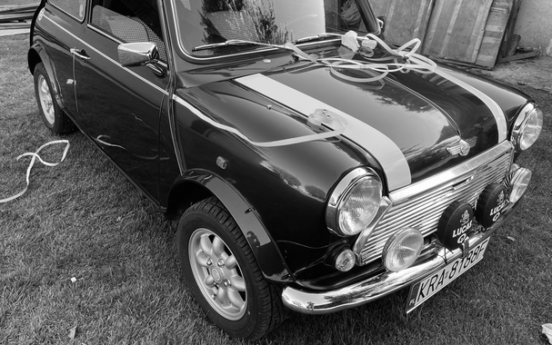 Black and white photography showing a section of a Rover Mini Cooper car produced in 1994, which I have owned for several years. The car has undergone an absolutely complete restoration and the photo shows the branding moment. I have just applied stickers in the form of stripes on the bonnet of the car at the front and on both sides of the body lengthwise. These stickers are typical to this car only.