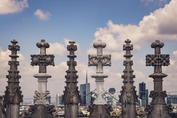 Detalles de las terrazas del Duomo de Milán con edificios actuales al fondo.