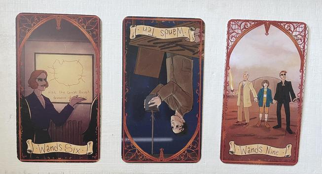 3 cards from a good omens tarot deck on a white background. 