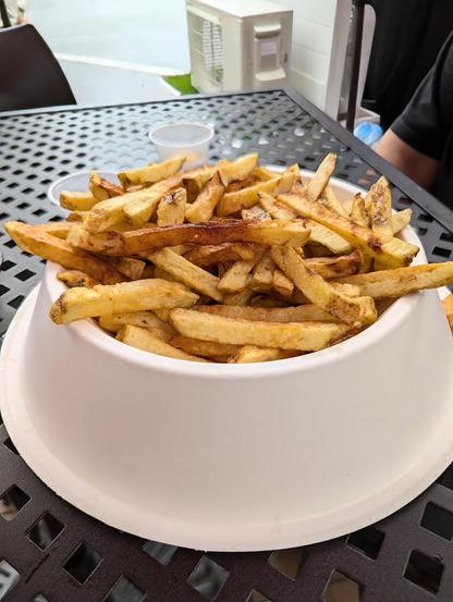 Image shows a cardboard bowl of French fries.