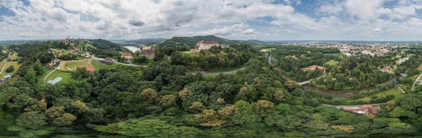 Ein Panorama Foto mit der Drohne. Zentral das Schloss Seggau, Links Frauenberg und der Sulmsee, Rechts Leibnitz. Im Vordergrund die Sulm und Teile der Auen bzw. die Wälder.
