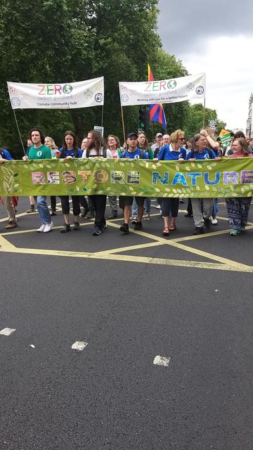 Image of several people holding a green banner with the words "Restore Nature Now"
