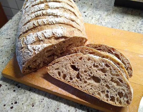 The rye bread has been sliced a little and the inner crumb is medium brown with evenly dispersed air holes. 