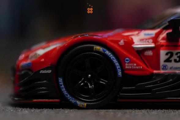 A close-up shot of Nissan GT-R Nismo GT500 No.23 “MOTUL AUTECH GT-R" NISMO ​2021 SUPER GT SERIES by MINI GT in 1:64 scale on AREA 164