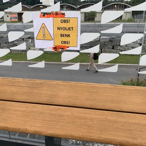 Plakat over en bussbenk hvor det står

OBS!
NYOLJET
BENK
OBS!