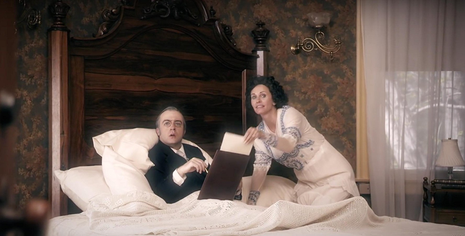 Scene from Drunk History where Edith Wilson props Woodrow Wilson up in bed to hide the fact that he's had a stroke