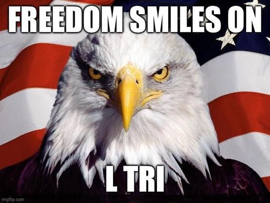Bald eagle in front of American flag with meme text that says “Freedom smiles on L Tri”
