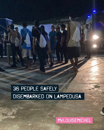 Menschen mit leichten Rucksäcken auf dem nächtlichen Pier auf Lampedusa.