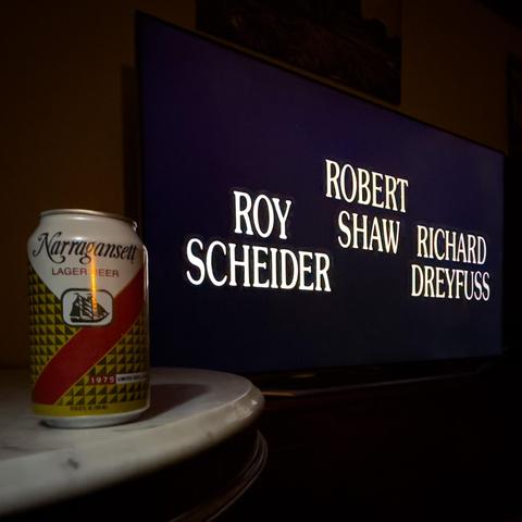 A photograph of a TV showing the opening credits showing the three leads of 