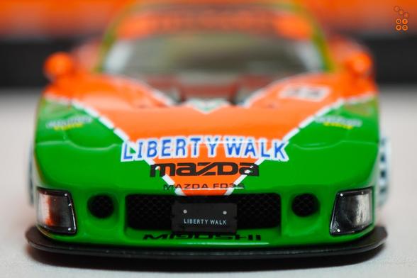 A close-up shot of Mazda RX-7 FD3S, LB-Super Silhouette Renown livery by iNNO64 in 1:64 scale with 1:64 figure on AREA 164
