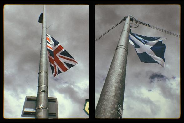Two vertical or portrait orientation pictures side by side. In each a flag flies attached to a large steel telegraph pole. One a union Jack, the other a Scotland Saltire.