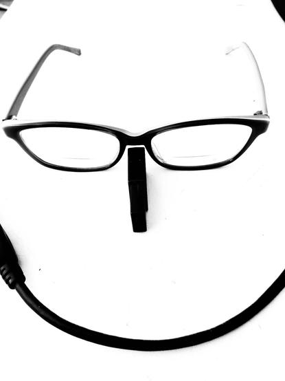 Monochrome picture, white background with a pair of glasses, a usb stick on its thin side for a nose a short USB extension cable as a mouth shaped to form a smile