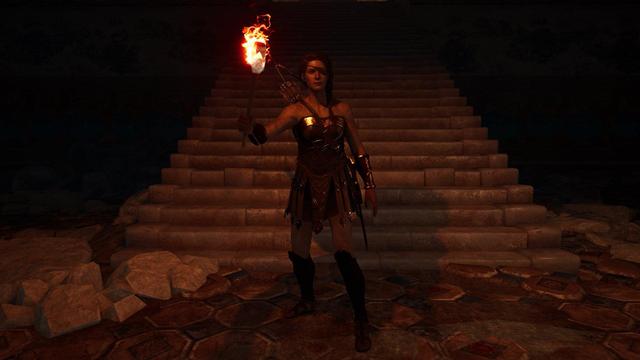 Kassandra from Assassins Creed Odyssey standing at the bottom of the stairs that are leading to the minotaur boss fight. She's wearing the leather amazon outfit and holds a torch in her right hand. :)
