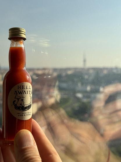 Handmade hot sauce called Hell Awaits with the Prague TV tower in the background.