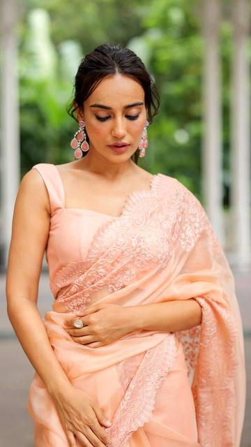Elegance personified! Surabhi Jyothi dazzles in a peach floral saree that is both chic and sophisticated. The beautiful floral designs add a touch of femininity to the traditional saree, while the peach color enhances her radiant glow. This stylish look is perfect for weddings, parties, and other special occasions. Learn how to achieve Surabhi Jyothi's flawless style and make a lasting impression with this exquisite saree.