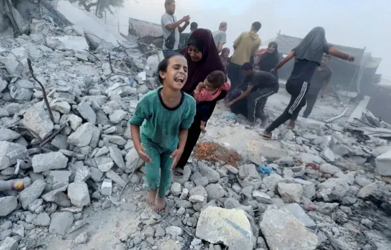 A Palestinian child cries following an Israeli strike near an UNRWA-run school sheltering displaced people in Khan Younis, southern Gaza, on July 3 [Mohammed Salem/Reuters]