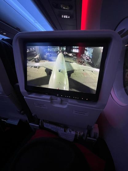 Photo of the in flight entertainment screen in front of me. It’s showing a camera view from the tail fin, overlooking the plane that is currently at the gate waiting for departure.