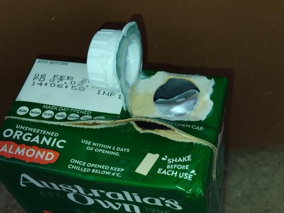 The upper end of the cardboard liquid container showing;
1. the ruptured security foil
2. the ruptured plastic screw-top fitting, and, 
3. the ruptured top seam.