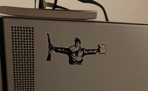 a sticker of john brown with a rifle in one hand and the bible in the other hand. the sticker is on the side of my computer.