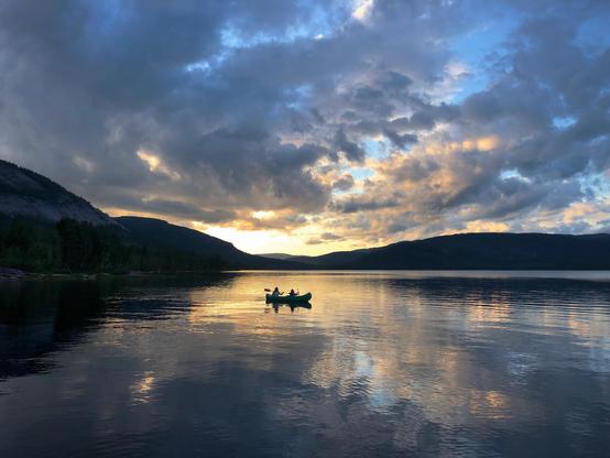 Peaceful Norwegian lake at dawn with 2 person on kayak