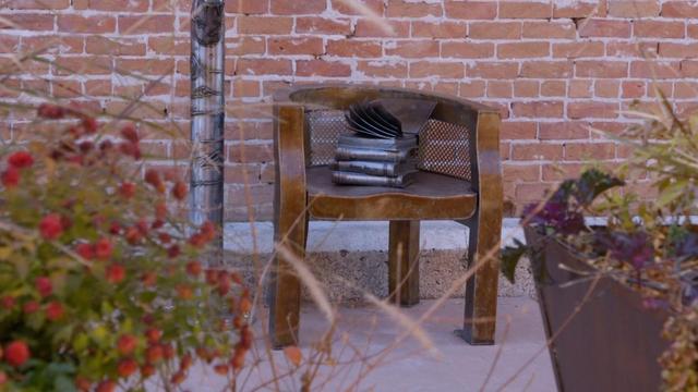 Warren Barnes memorial. A chair with a metal stack of books on the seat.