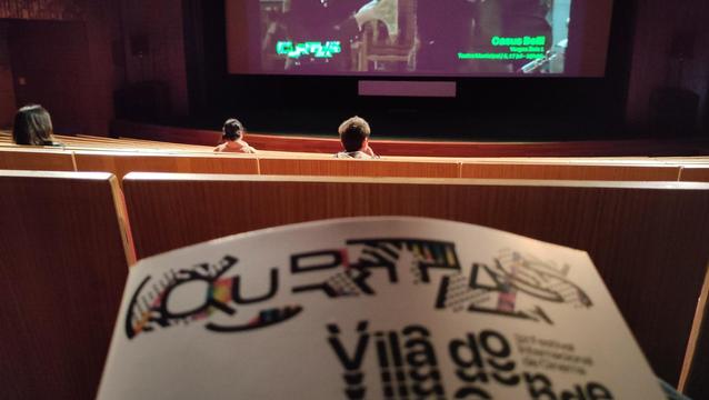 The programme of the curtas filmfest and some wooden seats in the screening room.
