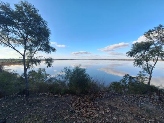 A view from the river. The calm waters make a very beautiful reflection of the blue sky and the few clouds.