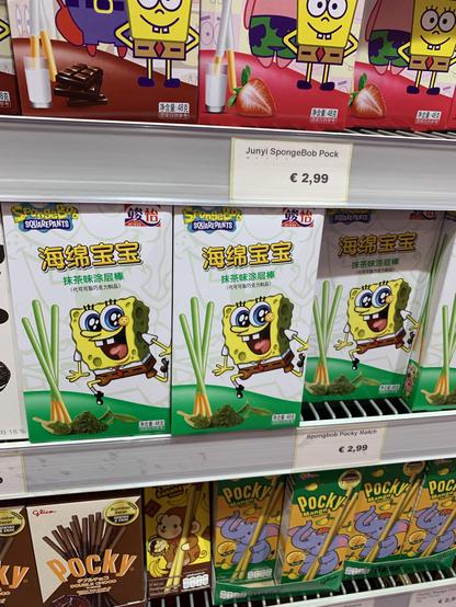 Boxes of various flavored Pocky sticks, including Junyi SpongeBob themed Pocky and Pocky Mango, displayed on a store shelf. The price tag reads €2.99.