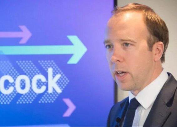 Matt Hancock, standing by a sign with his name on, but the frame has cut out the 'Han' from 'Hancock' to deliver insightful judgement on his character and abilities. 
Arrows point at his big fat head. 