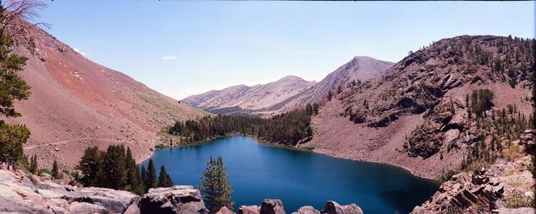 A panoramic view of a small blue lake surrounded by mountains