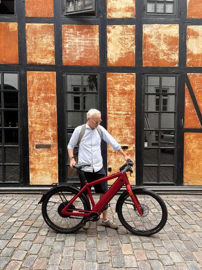 Seventeenth hundred, half-timbered facade with several windows as background, me with my Swiss Stromer speed pedelec in the foreground.
