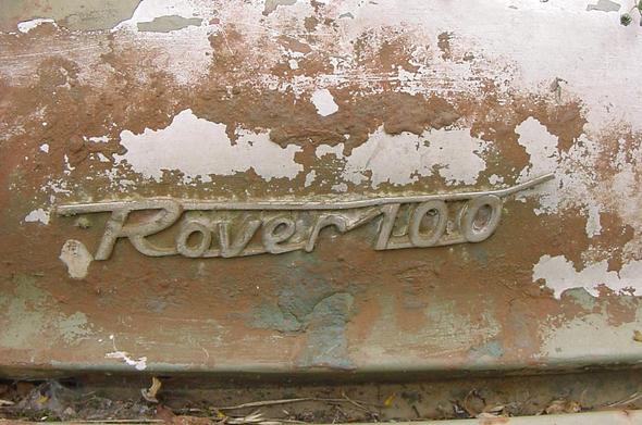 Close up of the car with brown rust around the model badge which says Rover 100
