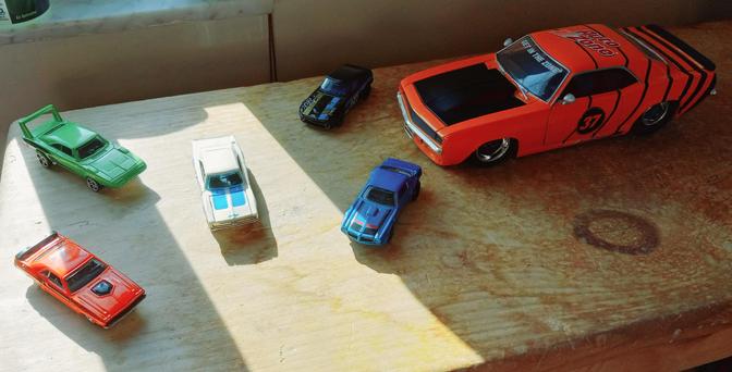 From left to right:

Orange '71 Dodge Challenger 

Lime green '69 Dodge Charger 

White w/ blue stripes '69 Dodge Charger

Black w/ blue/gold stripes Nissan Datsun 240Z 

Blue '73 Pontiac Firebird

Large orange '69 Chevy Camaro with the AutoZone logo, GET IN THE ZONE, and black stripes 


All purchased at Autozone while I worked there as a delivery driver (save for the white Charger, which was a gift).