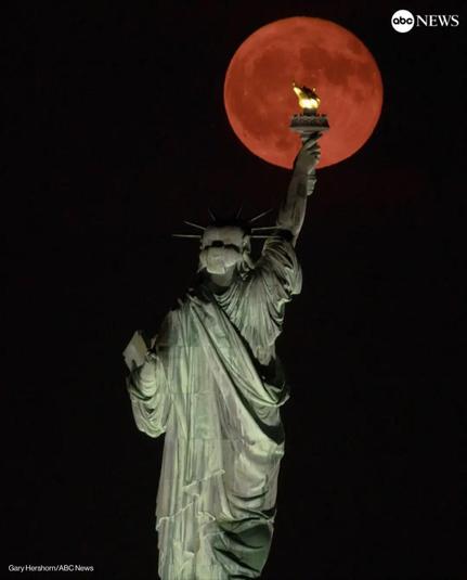Statue of Liberty in front of red full moon (real)