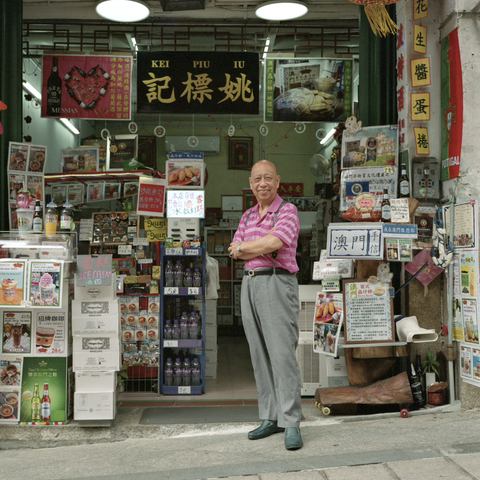 A colour film photo. Vicki poses in front of the small shop that he manages in Macao, China. Wednesday, July 3, 2024.