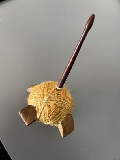 Turkish #spindle with quite uneven peach colored 2-plied #yarn of wool with some silk and viscose.