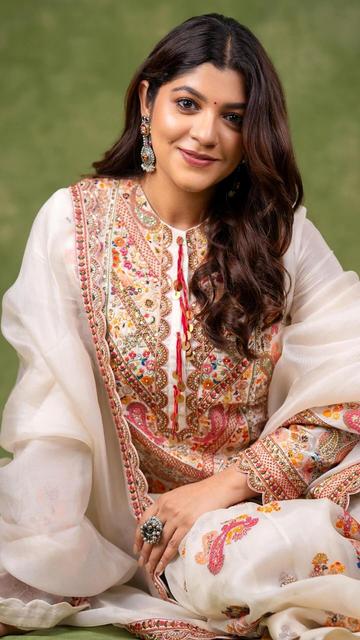 Aparna Balamurali effortlessly exudes elegance in this stunning off-white Anarkali suit. The intricate detailing and exquisite craftsmanship of the suit highlight her graceful charm, making her look absolutely breathtaking. This elegant ensemble is perfect for any traditional occasion, showcasing the beauty of ethnic wear with a modern twist. Aparna's poised and refined style in this Anarkali is a testament to her impeccable fashion sense. Dive into her sophisticated look now!