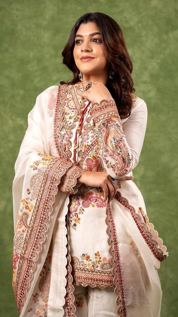 Aparna Balamurali dazzles in a beautiful off-white Anarkali suit, showcasing a blend of traditional elegance and contemporary style. The detailed embroidery and fine craftsmanship highlight her natural grace and sophisticated fashion sense. This stunning outfit is perfect for festive events and celebrations, reflecting a timeless charm. Aparna's elegant look in this Anarkali suit is a must-see for all fashion enthusiasts. Explore her enchanting style and get inspired!