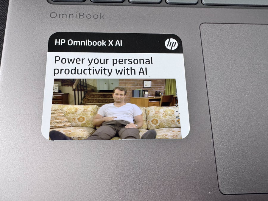 a HP sticker "Power your personal productivity with AI" but assuming it's spelled "Al" as in "Al Bundy" with a picture of Al Bundy on the couch pasted in