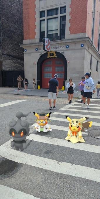 A Pokémon GO AR photograph of professor Pikachu, Pikachu dressed as Mimikyu, and Marshadow at the Ghostbusters' Hook and Ladder Firehouse.