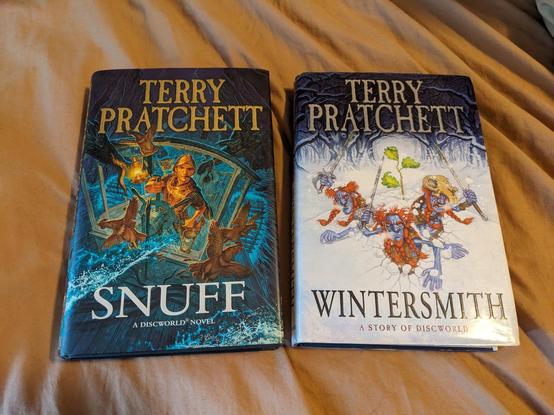 Hardcover copies of Snuff and Winter Smith by Terry Pratchett