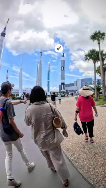 Photo of three people walking toward the Rocket Garden at Kennedy Space Center Visitor Complex.