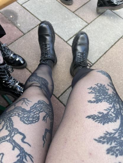 My legs with sheer black tights and black laces boots. My tree tattoos are visible.