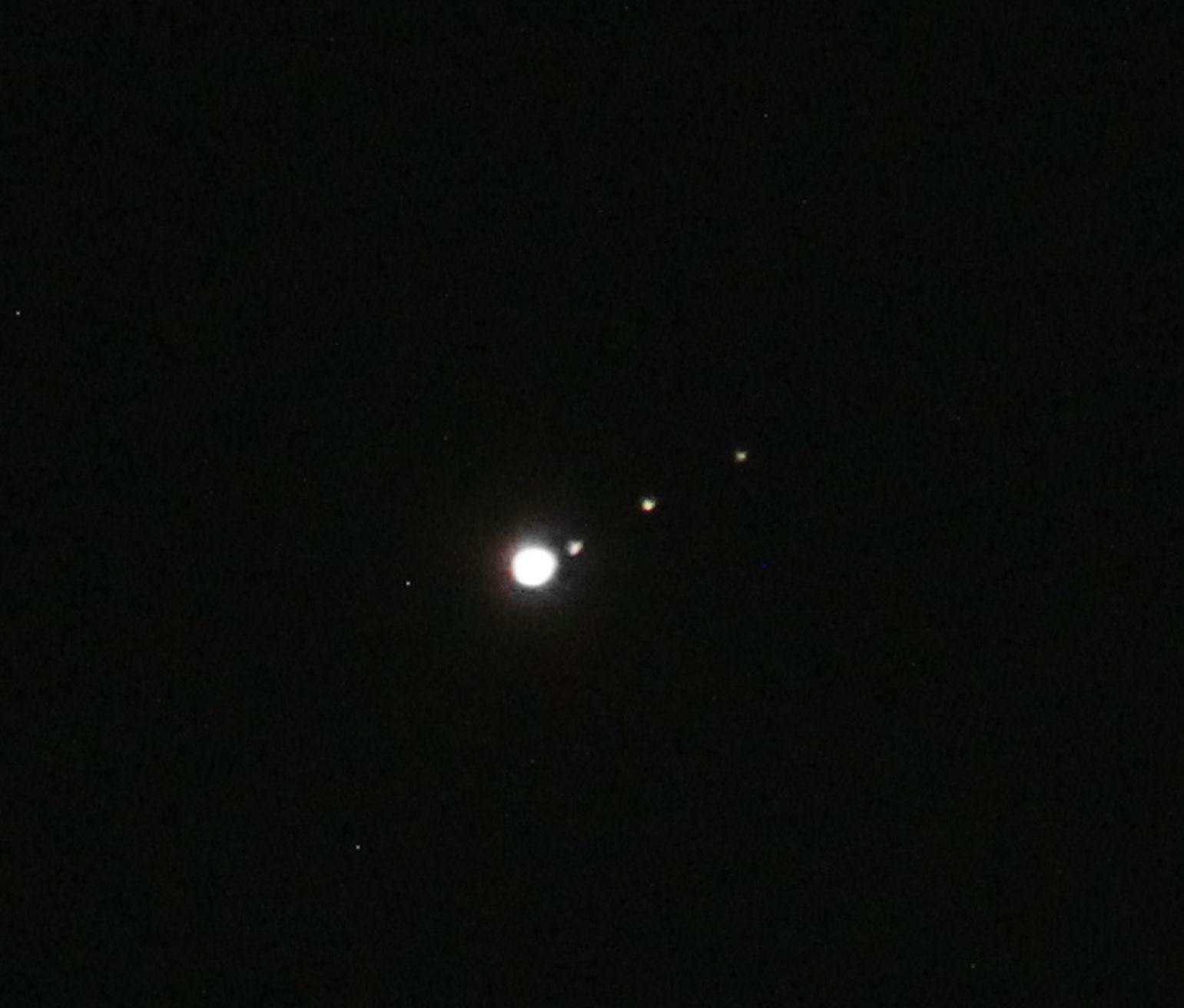 Planet Jupiter at centre with all Galilean moons to its right. 