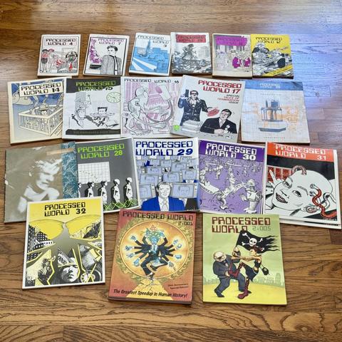 A large collection of Processed World zines laying on the ground. They are laid out in chronological order. With only a few issues missing. 