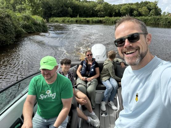 Mark steering the boat, me smiling. Family in the background. 