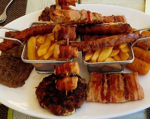 A big plate with a lot of different cooked meats. 