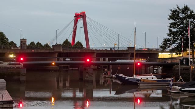 Red cable bridge over a river with some red lights