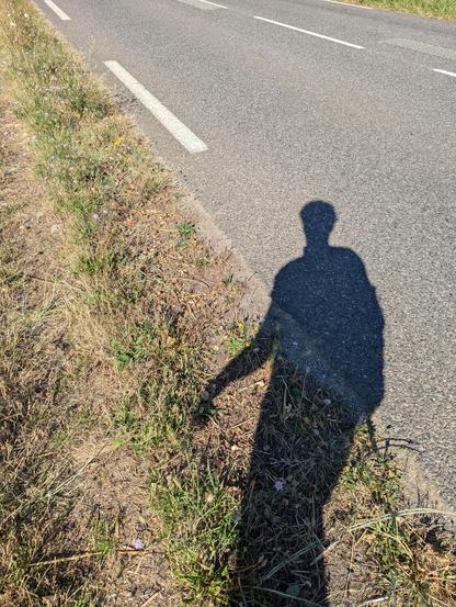 Ombre du marcheur (et photographe) marchant le long d'une route départementale.