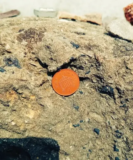 1 pence coin placed into recess in standing stone